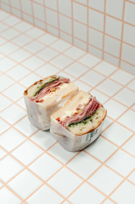 Deli meats sandwich with shaved cured meat and pesto